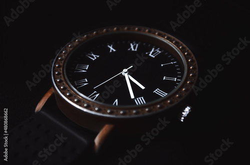 Men's accessory. Clock with Roman numerals on a black background