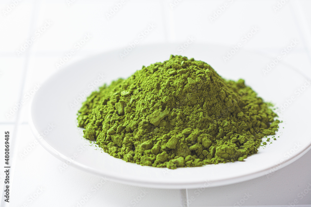 Matcha green tea powder on a white plate.