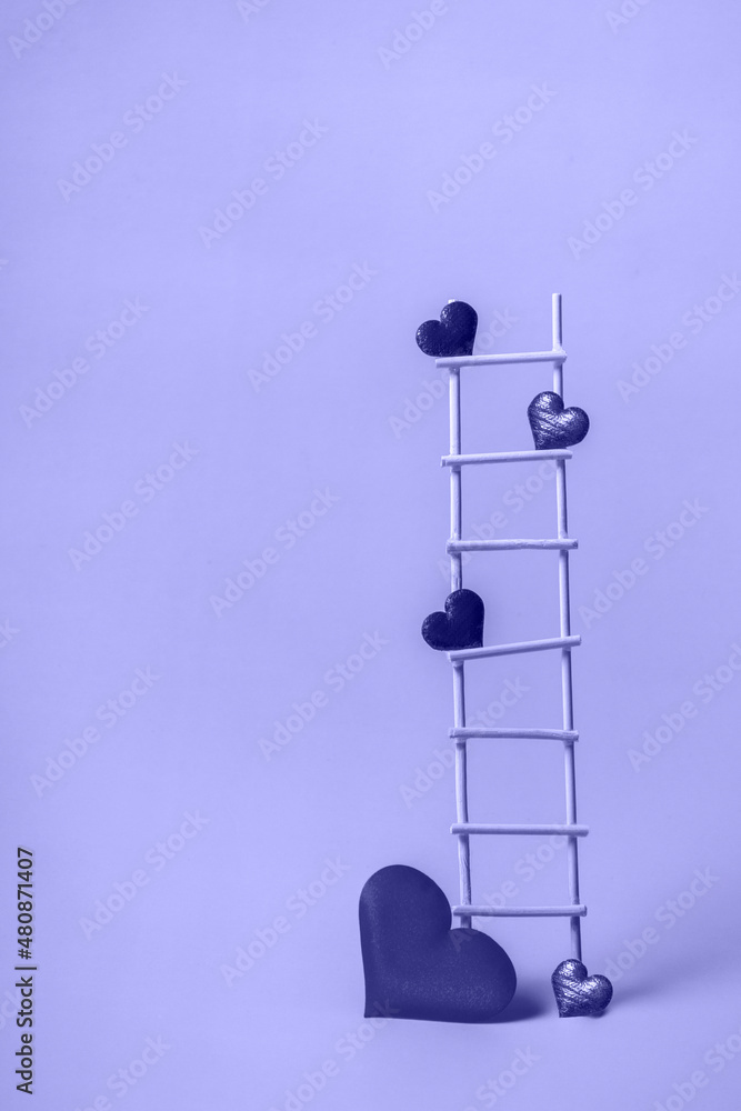 Wooden ladder with red hearts on a very peri background. Postcard or invitation template. Closeup