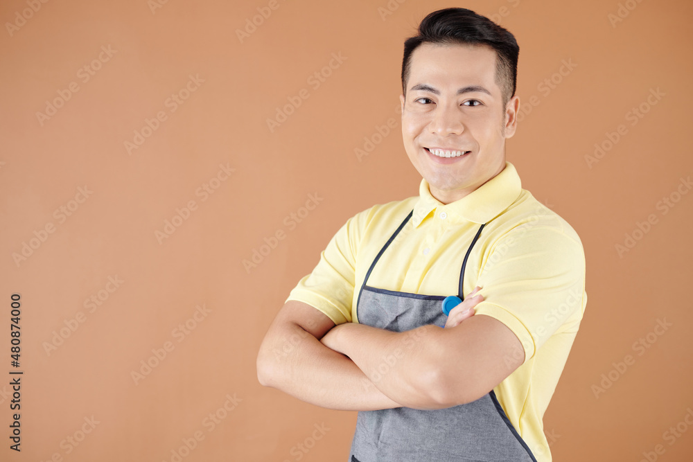 Portrait of happy smiling coffeeshop barista in apron standing with arms crossed and looking at camera Portrait of happy smiling coffeeshop barista in apron standing with arms crossed and looking at camera