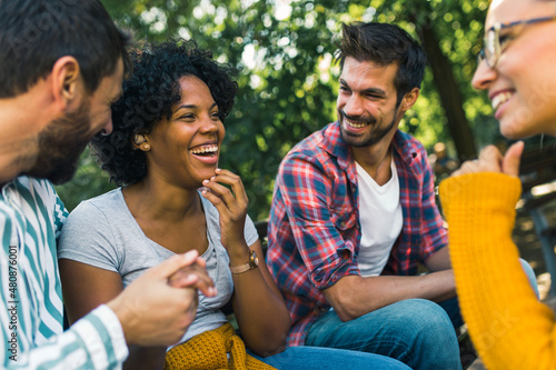 Woman with ear hearing problem having fun with her friends in the park