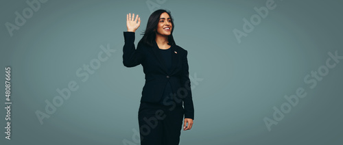 Congresswoman waving her hand against a studio background photo