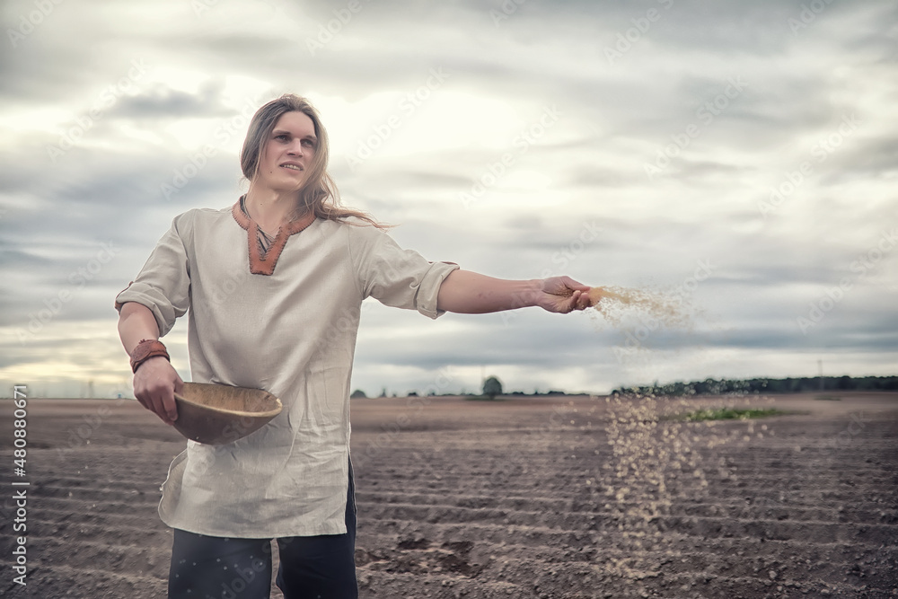 A young peasant sows the field with grain A young peasant sows the field with grain