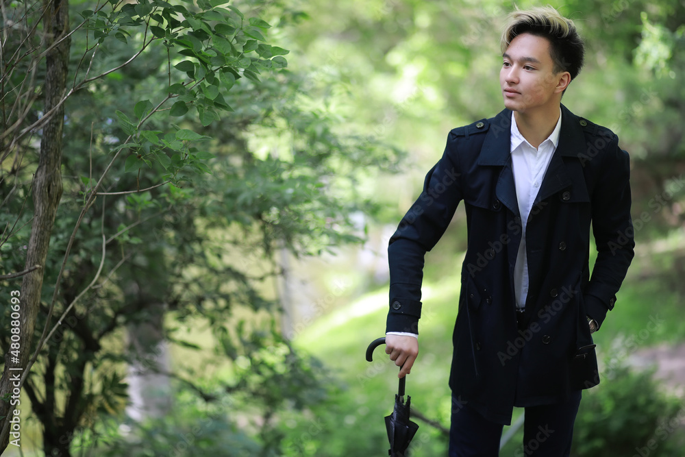Spring rainy weather and a young man with an umbrella Spring rainy weather and a young man with an umbrella
