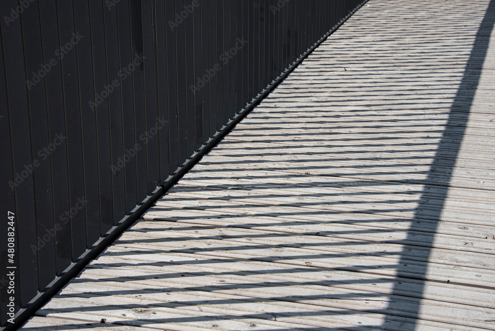 a metal railing casting shadows on a bridge a metal railing casting shadows on a bridge