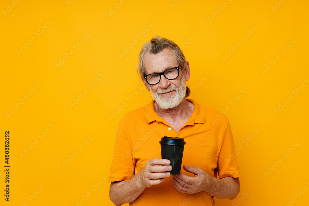 Portrait of happy senior man with black disposable cup isolated background Portrait of happy senior man with black disposable cup isolated background