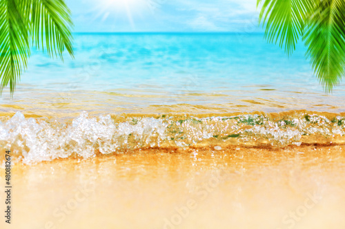 Fototapeta Naklejka Na Ścianę i Meble -  Tropical island beach nature, blue sea wave, turquoise ocean water, yellow sand, green palm tree leaves, sun, sky, white clouds, summer holidays background, vacation concept, travel design, copy space