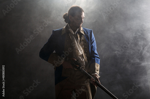 American revolution war soldier with flag of colonies and musket gun over dramatic smoke background Fototapet