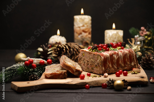 Fototapeta Naklejka Na Ścianę i Meble -  Traditional French terrine covered with bacon and Christmas decoration on dark wooden background