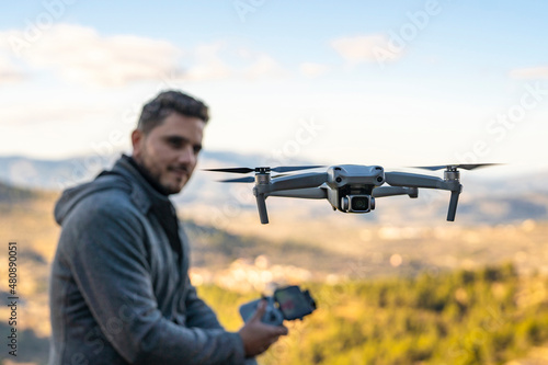 Unmanned aerial vehicle flying in front of drone pilot photo