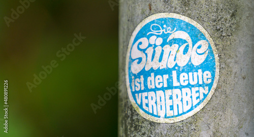 Foto Verwitterter farbiger Aufkleber an einem Metallpfosten