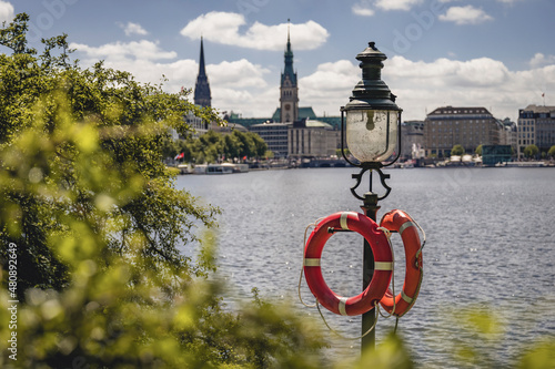 Germany, Hamburg, Life belts hanging on street light standing on shore of Inner Alster Lake photo