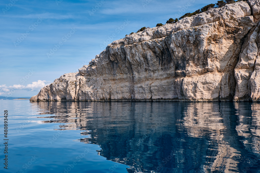 cliffs above the calm sea with water reflection