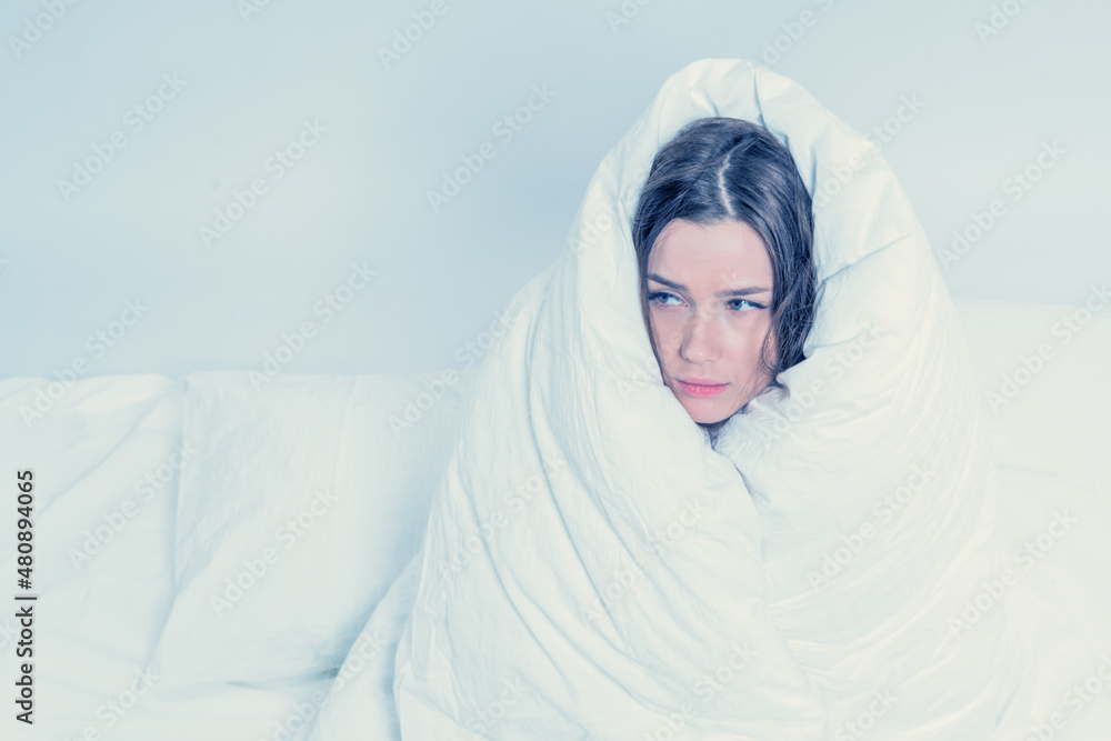 A pretty brunette, wrapped in a blanket, sits on the bed. Keep warm with a warm blanket. Fear. Excitement. A pretty brunette, wrapped in a blanket, sits on the bed. Keep warm with a warm blanket. Fear. Excitement.
