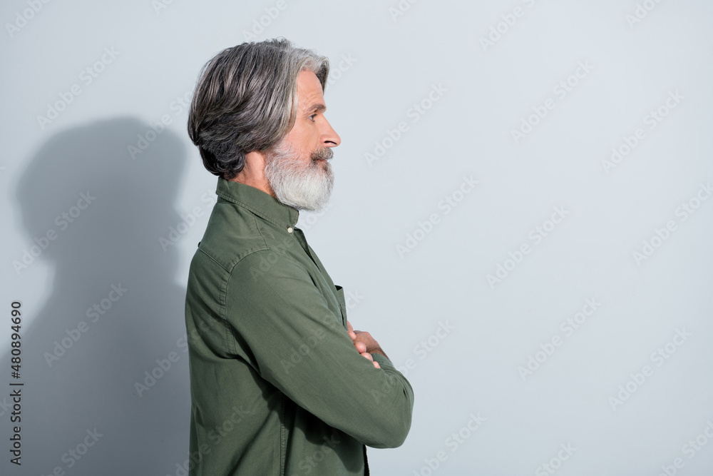 Profile side view portrait of attractive content grey-haired man copy space folded arms isolated over gray pastel color background Profile side view portrait of attractive content grey-haired man copy space folded arms isolated over gray pastel color background