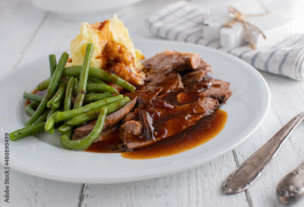 Plate with roast meat, gravy, mashed potatoes and green beans Plate with roast meat, gravy, mashed potatoes and green beans