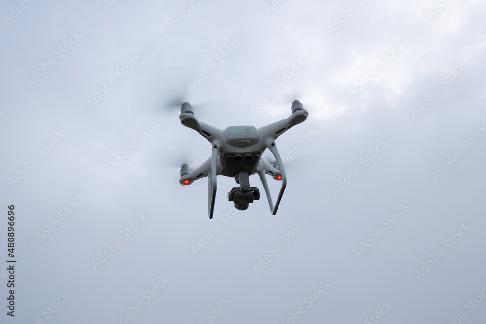 White drone with camera flying in summer mountain top White drone with camera flying in summer mountain top
