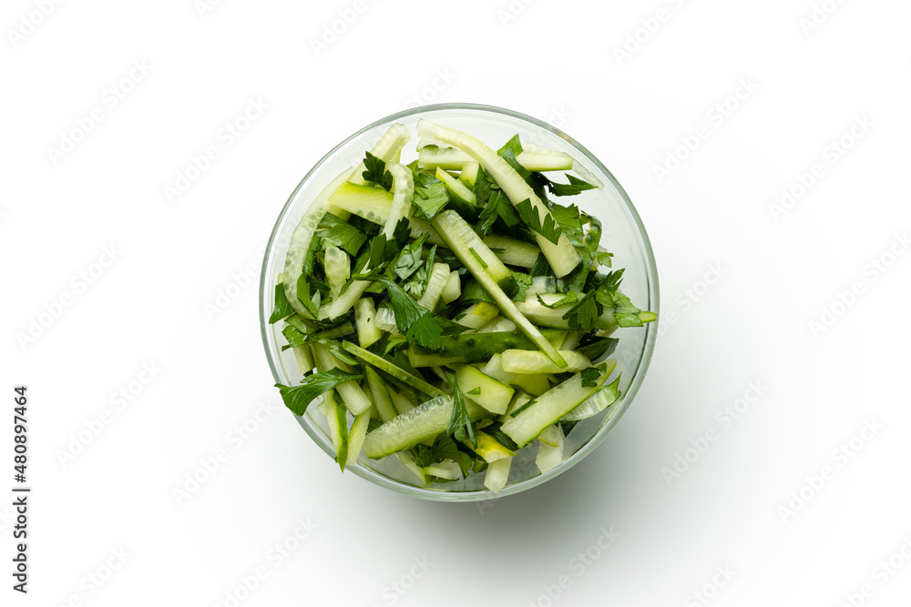sliced cucumber with parsley in a transparent plate on a white background sliced cucumber with parsley in a transparent plate on a white background