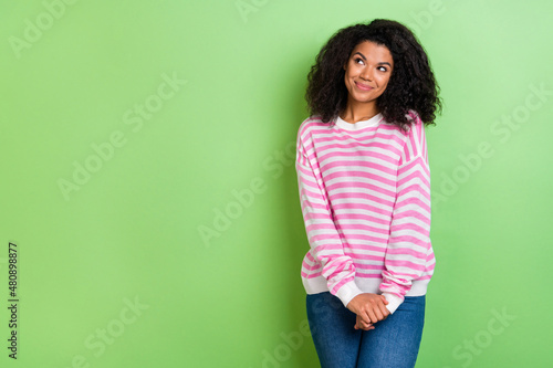 Portrait of attractive cheery cute shy girl guessing clue thinking copy space isolated over bright green color background