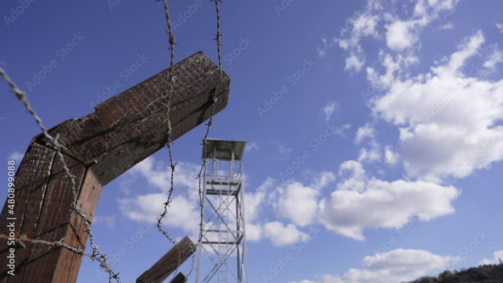 A prison guard tower against a cloudy blue sky