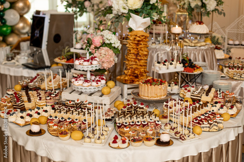 Candy Bar. Wedding sweet table with various desserts beautifully decorated at banquet. Buffet with delicious pastries. Delicious wedding buffet with cupcakes. Festive event.