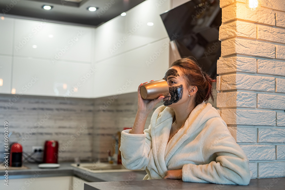 beautiful young girl in home clothes with a black mask resting at home. beautiful young girl in home clothes with a black mask resting at home.