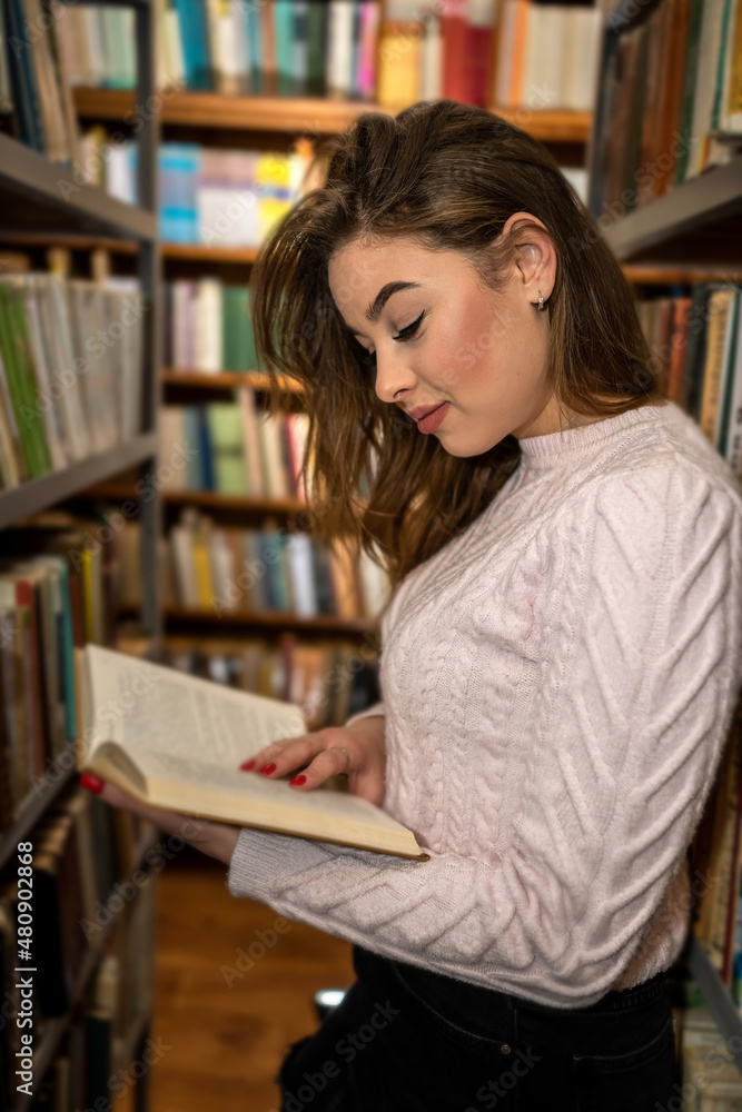 student girl reading book at university library student girl reading book at university library