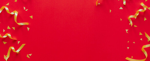 close up on group of gold color of rolling ribbon and confetti on red  background with copy space for happy Chinese new year ,festival ,birthday and anniversary, concept design