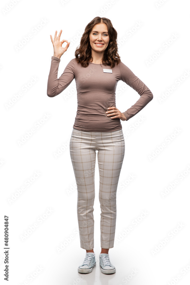 sale, shopping and business concept - happy female shop assistant or saleswoman with name tag showing ok gesture over white background sale, shopping and business concept - happy female shop assistant or saleswoman with name tag showing ok gesture over white background