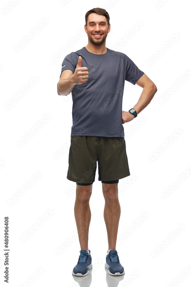 Fototapeta premium fitness, sport and healthy lifestyle concept - smiling man in sports clothes with smart watch or tracker showing thumbs up over white background