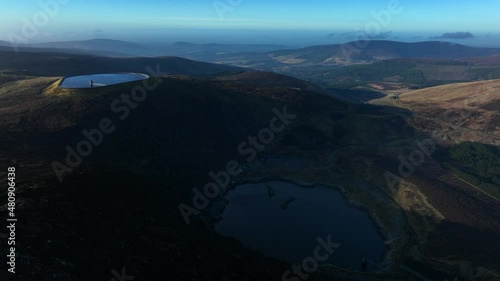 Turlough Hill, Wicklow, Ireland. January 2022 Drone gradually orbits from the south facing Lough Nahanagan and the upper Reservoir with Mullaghcleevaun mountain and Blessington in the distance. photo