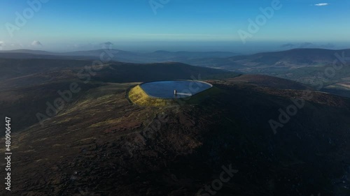 Turlough Hill, Wicklow, Ireland. January 2022 Drone gradually pushes towards the upper Reservoir with Mullaghcleevaun mountain and Blessington in the distance. photo