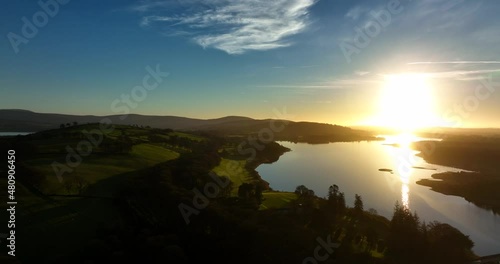 Blessington Lakes, Wicklow, Ireland. January 2022 Drone pulls across Boystown from the north above the Poulaphouca reservoir with a golden wintery sunset on the horizon. photo