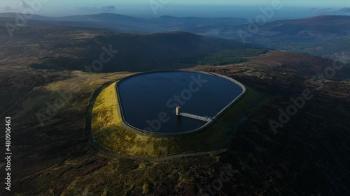 Turlough Hill, Wicklow, Ireland. January 2022 Drone gradually orbits the upper Reservoir from the southeast on a bright wintery afternoon with Mullaghcleevaun mountain and Blessington in the distance. photo