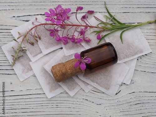 Tea bags, tincture, chamerion angustifolium with pink flowers on a white wooden table. Useful plant epilobium parviflorum for use in herbal alternative medicine, homeopathy and cosmetology photo