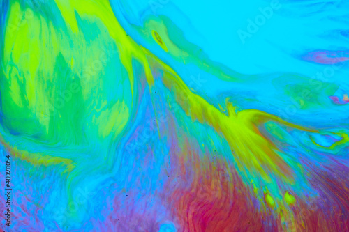 Bright creative texture made by floating paints. Macro photography of flowing inks