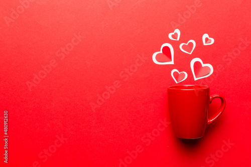 red cup on colored background, splashes of red little hearts, top view with copy space