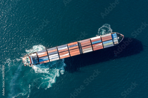 Sea container ship is moving at sea. Around the foam from the work of the screw. View of the ship from above.