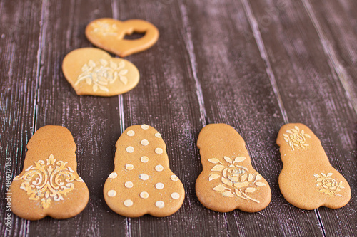 Gingerbread penis and heart shaped cookies on gray-light blue wooden background