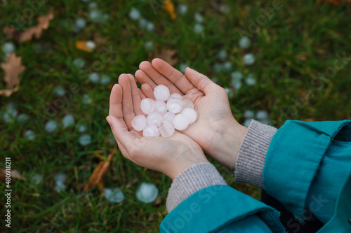 Woman holding hail grains after thunderstorm outdoors, closeup