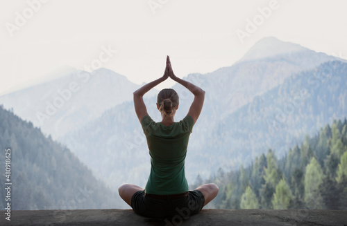 Photography Young woman practicing yoga in mountains at sunset