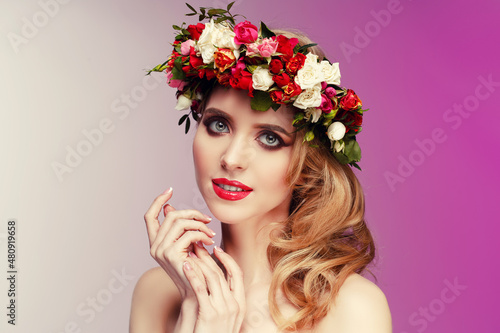Girl in a wreath of spring flowers. Spring beauty. Woman with flowering plants in her hair. © Miramiska