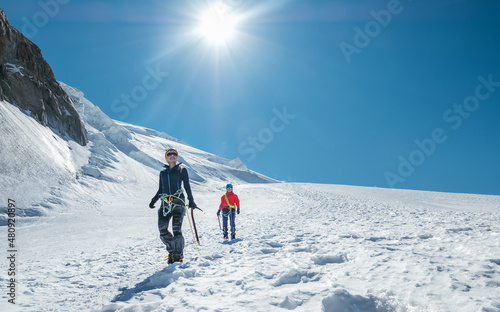 Two laughing young women Rope team descending Mont blanc du Tacul summit 4248m dressed mountaineering clothes with ice axes walking by snowy slopes Fototapete