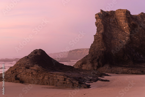 Rocks and cliff of Praia do Almograve at sunset photo