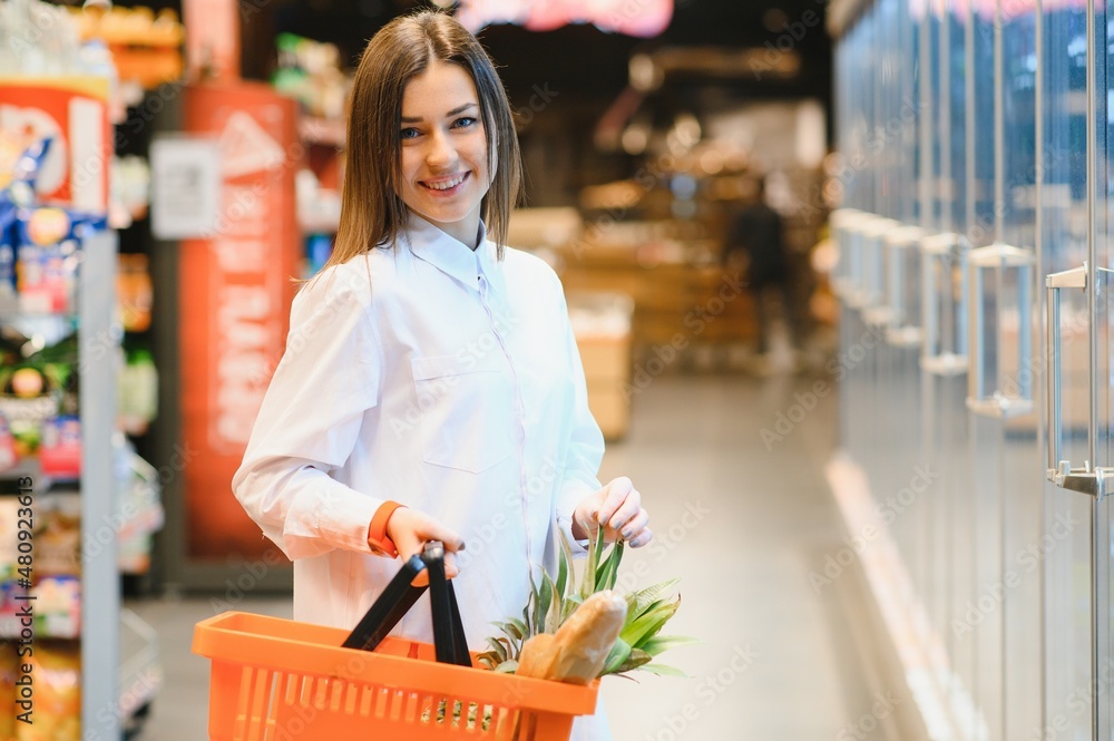 Woman grocery shopping and looking very happy