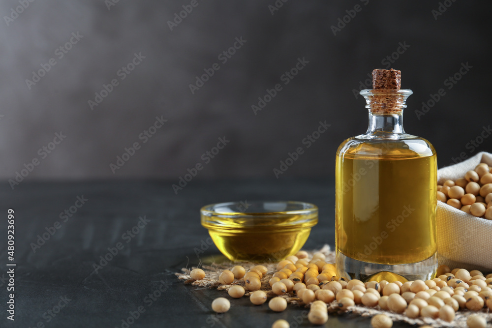 Composition with soybean oil on grey table. Space for text Composition with soybean oil on grey table. Space for text