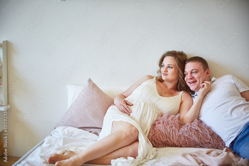 Young family on the bed in the bedroom Young family on the bed in the bedroom