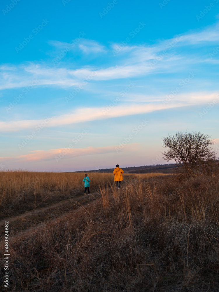 Travelers father and daughter walking together on hill enjoying scenic landscape blue cloudy sunset sky back view. Active Lifestyle nature tourism. Family local travel hiking trail journey Backpacking Travelers father and daughter walking together on hill enjoying scenic landscape blue cloudy sunset sky back view. Active Lifestyle nature tourism. Family local travel hiking trail journey Backpacking