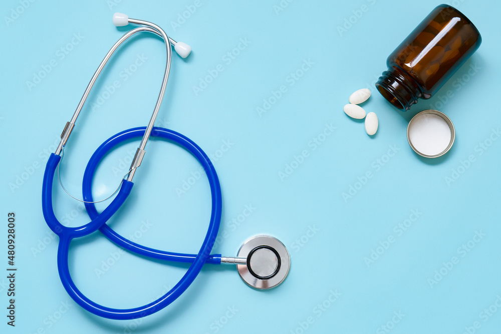 stethoscope and pills on blue background top view , Flat lay medical and Health care or illness Concept. stethoscope and pills on blue background top view , Flat lay medical and Health care or illness Concept.