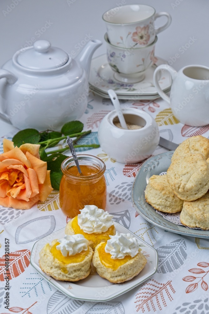 Fresh scones with homemade apricot jam topped with whipped cream Fresh scones with homemade apricot jam topped with whipped cream